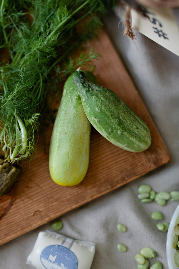 Fresh from the vine cucumbers and dill on a cutting board