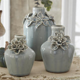 Small light blue ceramic vase with a raised flower